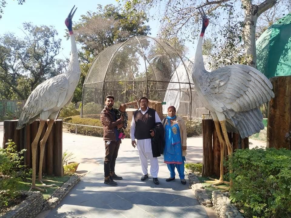 Family at Chhatbir Zoo with crane sculptures, Chandigarh
